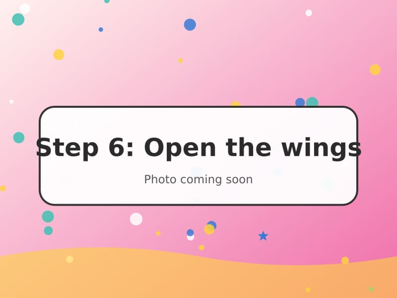 A finished pink origami crane with wings spread