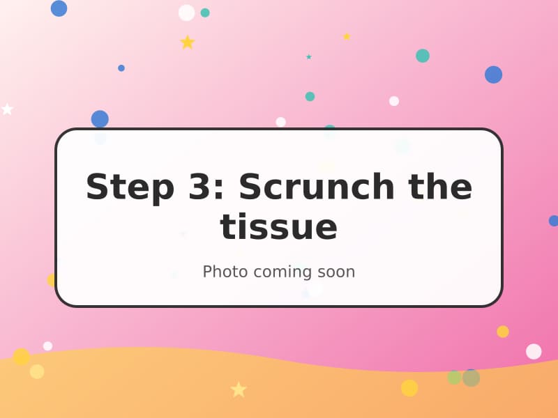 Small hands scrunching coloured tissue paper into balls